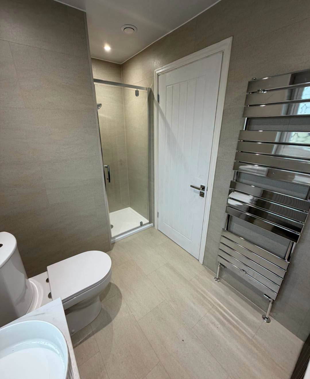 Shower enclosure, toilet and chrome towel rail