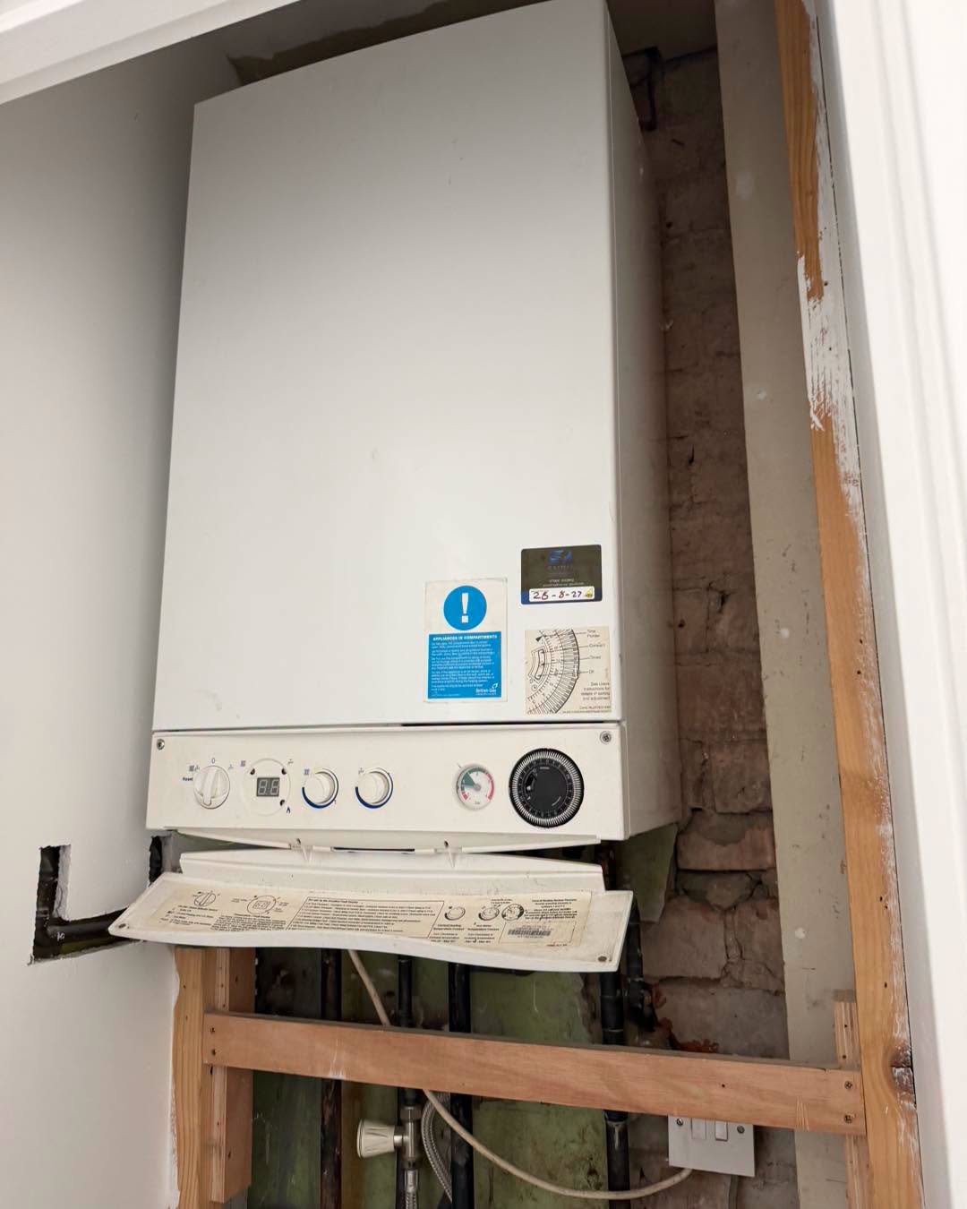 Boiler sitting in a cupboard during installation