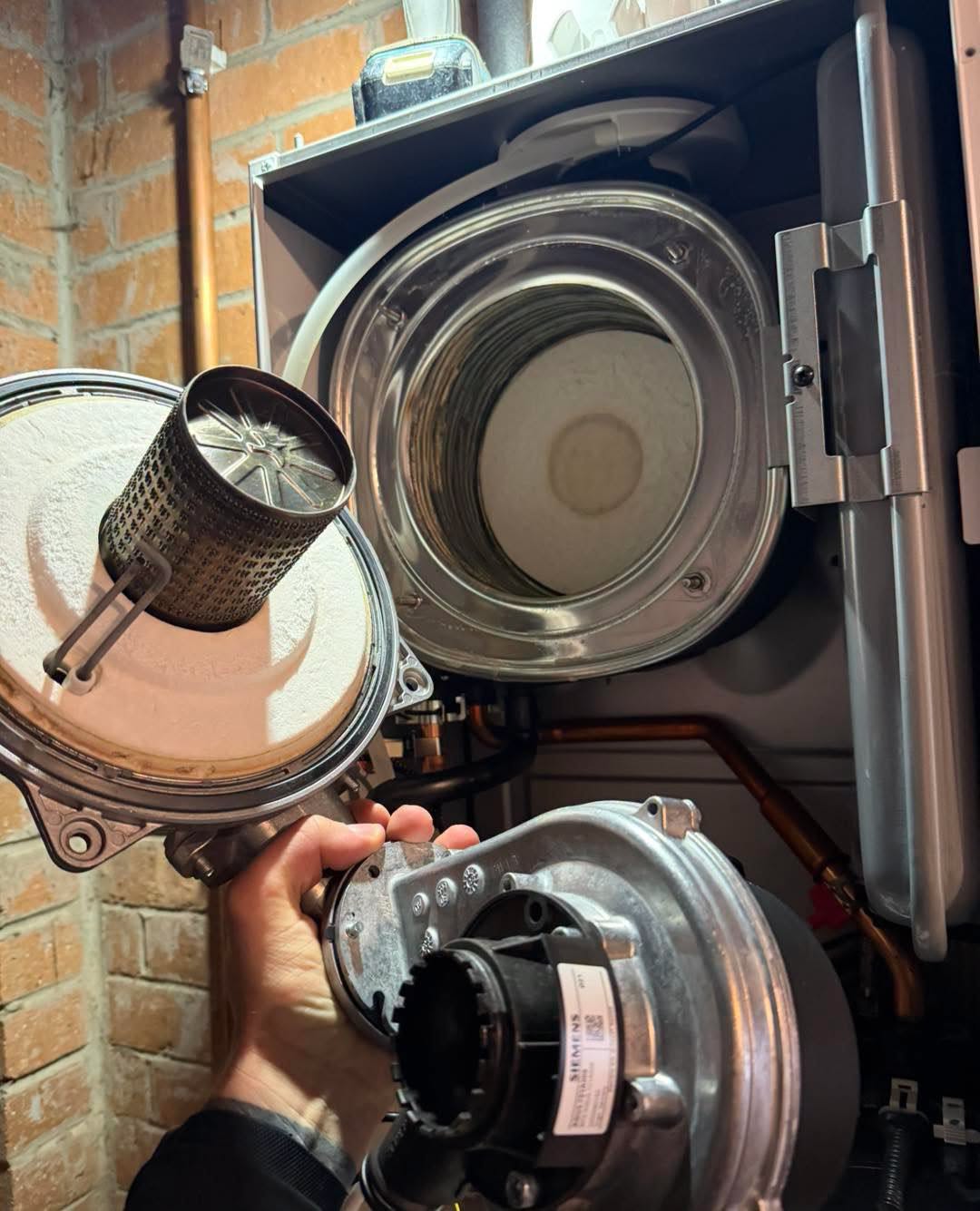 Service on a boiler against a brick wall.