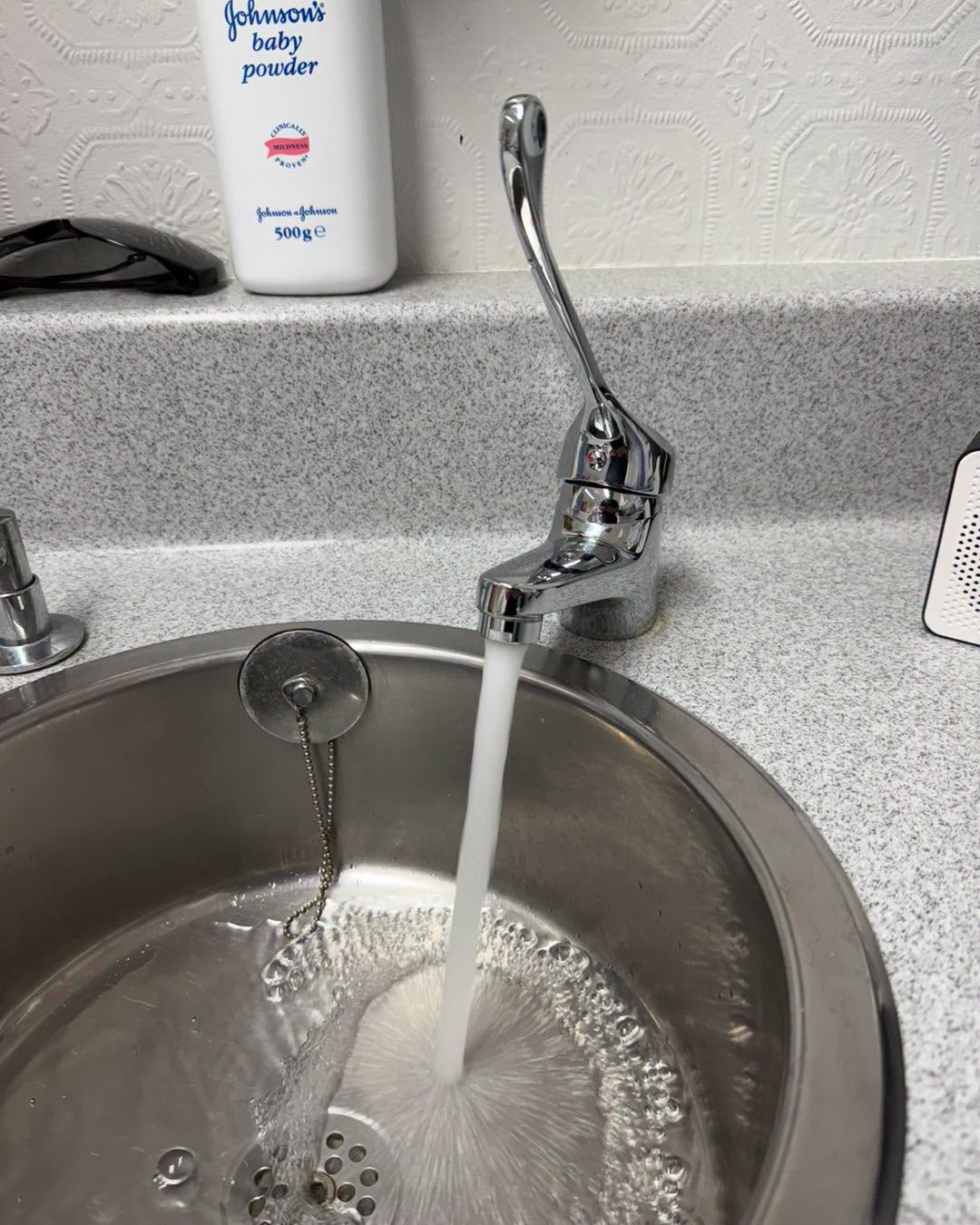 Lever tap into a round stainless basin.